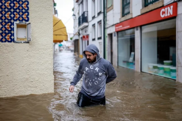Чоловік переходить убрід, коли паводкові води з річки Садо затопили вулицю в Алкасер-ду-Сал, на півдні Португалії, під час шторму Леонардо 4 лютого 2026 року.