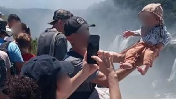 На фото зображено чоловіка, який тримає немовля на руках біля гори Диявола, водоспади Ігуасу, Аргентина, 17 лютого 2026 року.