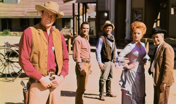 У ролях серіалу «Gunsmoke» (зліва направо): Джеймс Арнесс у ролі маршала Метта Діллона, Берт Рейнольдс у ролі Квінта Аспера, Кен Кертіс у ролі заступника шерифа Фестуса Хаггена, Аманда Блейк у ролі Кітті Рассел та Мілберн Стоун у ролі Галена «Дока» Адамса.