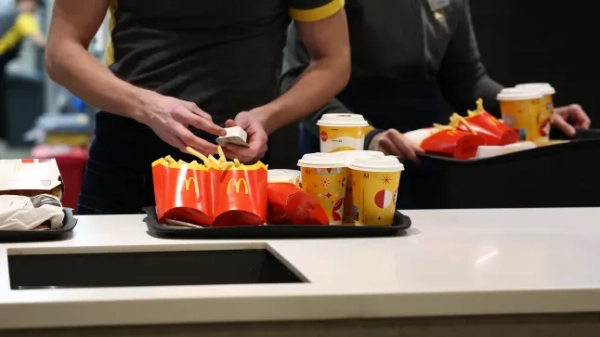 Ресторан McDonald's, чоловік тримає майонез, а перед ним стоїть піднос з їжею.