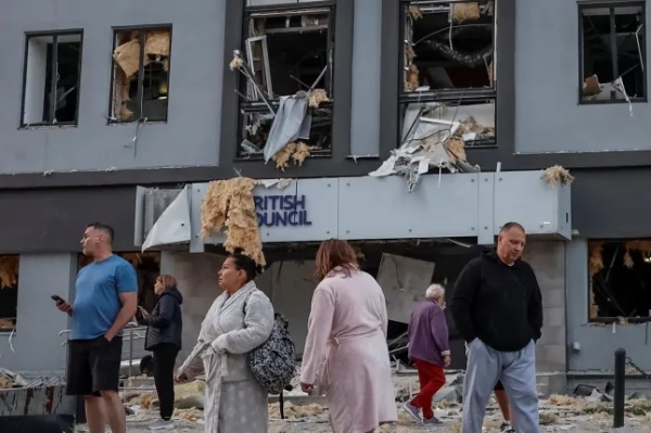 Люди стоять на місці будівлі, в якій розміщується місцеве відділення Британської Ради, після того, як вона була уражена під час російських ракетних ударів та ударів безпілотників на тлі нападу Росії на Україну, у Києві, Україна, 28 серпня 2025 року. REUTERS/Аліна Смутко