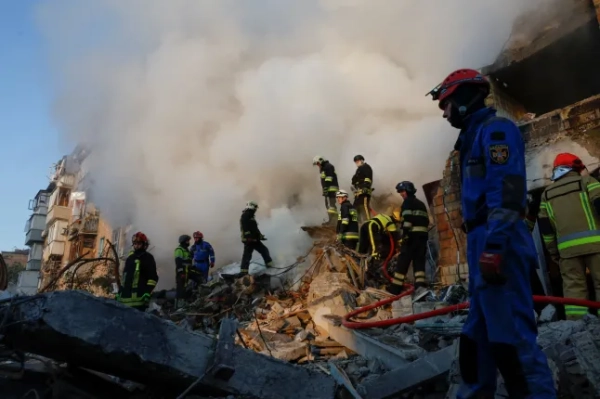 Рятувальники працюють на місці багатоквартирного будинку, який постраждав від російського ракетного удару та удару безпілотника на тлі нападу Росії на Україну, у Києві, Україна, 28 серпня 2025 року. REUTERS/Thomas Peter