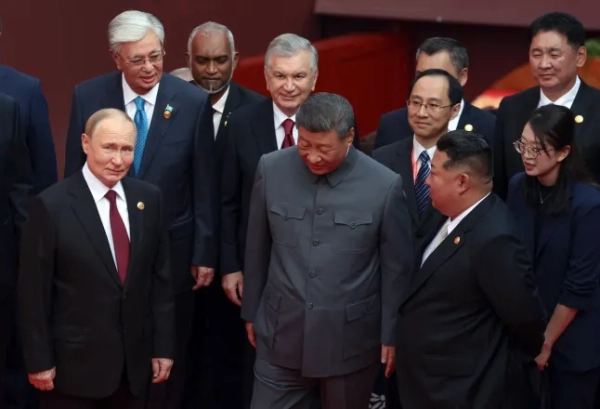 На цьому фото з басейну, поширеному російським державним агентством «Супутник», президент Росії Володимир Путін (ліворуч) розмовляє з президентом Китаю Сі Цзіньпіном (в центрі) та лідером Північної Кореї Кім Чен Ином (праворуч) після групового фото перед військовим парадом, присвяченим 80-й річниці перемоги над Японією та завершення Другої світової війни, на площі Тяньаньмень у Пекіні 3 вересня 2025 року. (Фото Олександра КАЗАКОВА / POOL / AFP) (Фото ОЛЕКСАНДРА КАЗАКОВА/POOL/AFP via Getty Images)