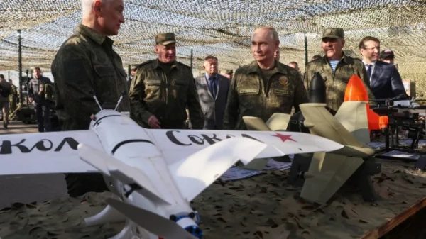 Президент Росії Володимир Путін у супроводі міністра оборони Росії Андрія Бєлоусова (ліворуч) та головнокомандувача Сухопутних військ Росії Андрія Мордвічева (другий ліворуч) оглядає російську зброю.