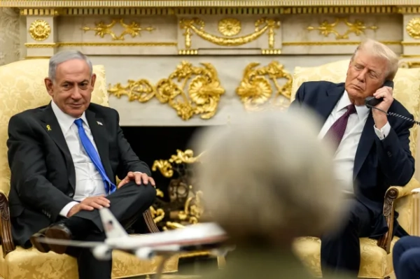 опублікували фотографії похмурого Трампа з телефоном, незграбно розташованим на колінах.