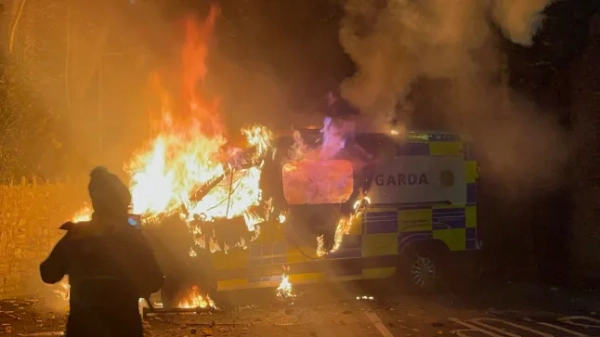 Очевидці зняли на відео палаючий поліцейський автомобіль, коли демонстрація біля готелю, де проживають шукачі притулку, переросла в насильство в Саггарті, на південний захід від Дубліна в Ірландії, 21 жовтня 2025 року. У вівторок поліція у спорядженні для боротьби з масовими заворушеннями зіткнулася з щонайменше 500 протестувальниками в Дубліні біля готелю для шукачів притулку після звинувачень у сексуальному насильстві над 10-річною дівчинкою. (Фото Пітера Мерфі / AFP) (Фото ПІТЕРА Мерфі/AFP через Getty Images)