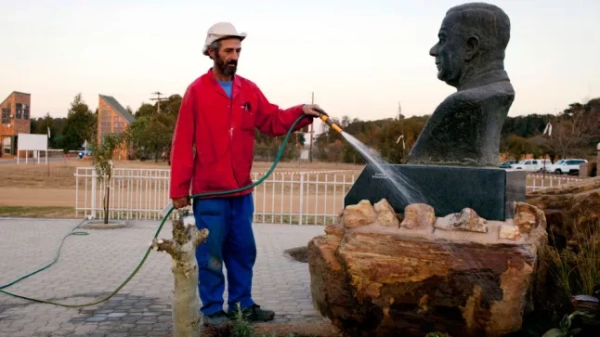 КЛЯЙНФОНТЕЙН, ПІВДЕННА АФРИКА – Працівник муніципалітету поливає суперечливу статую