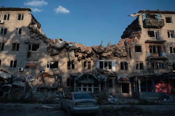 На цій фотографії, зробленій 27 вересня 2025 року, видно автомобіль, припаркований поруч зі зруйнованою будівлею в Авдіївці, контрольованій Росією Донецькій області України, на тлі триваючого російсько-українського конфлікту. (Фото Андрія БОРОДУЛІНА / AFP) (Фото АНДРІЯ БОРОДУЛІНА/AFP via Getty Images)