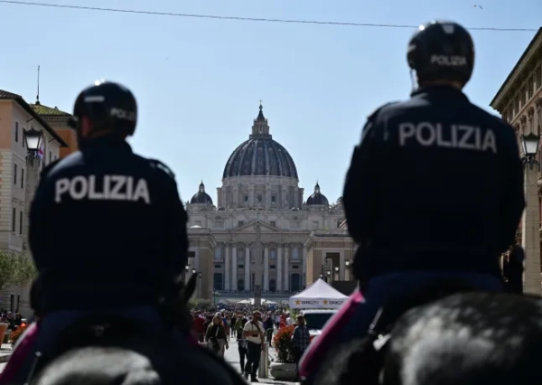 Двоє італійських поліцейських патрулюють верхи на конях вулицю Віа делла Кончиліаціоне на тлі базиліки Святого Петра у Ватикані через день після смерті Папи Римського в Римі, 22 квітня 2025 року. Папа Римський помер від інсульту, оголосив Ватикан через кілька годин після смерті 21 квітня 2025 року 88-річного реформатора, який надихав на відданість, але дратував традиціоналістів протягом 12 років керівництва Католицькою церквою. (Фото Андрія Ісаковича / AFP) (Фото АНДРЕЙ ІСАКОВИЧ/AFP via Getty Images)