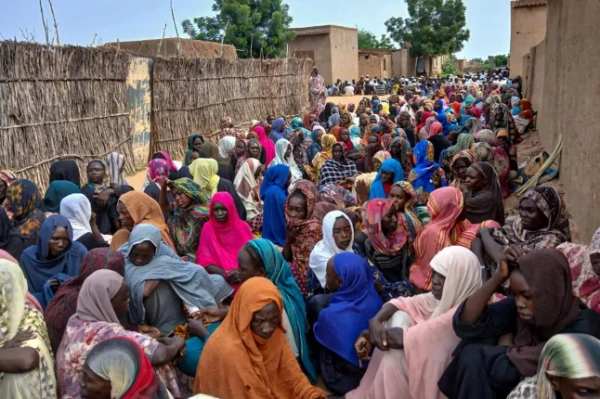 (ФАЙЛИ) Мешканці Судану зібралися, щоб отримати безкоштовне харчування в Ель-Фашері, місті, яке понад рік облягають воєнізовані Сили швидкої підтримки (RSF) Судану, в регіоні Дарфур, 11 серпня 2025 року. Губернатор Дарфура, союзник суданської армії, 27 жовтня 2025 року закликав до «захисту цивільного населення» в охопленому голодом місті Ель-Фашер після того, як воєнізовані Сили швидкої підтримки (RSF) заявили про захоплення міста під контроль. (Фото AFP) (Фото STR/AFP через Getty Images)