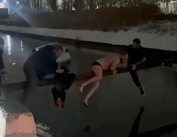 Чоловік у штанях серед трьох, хто врятував хлопчика з таксі, що затонуло в крижаній річці 1