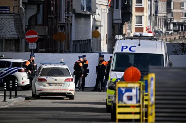 Бельгійська поліція охороняє периметр, встановлений навколо синагоги на вулиці Леона Фредеріка після того, як у ній вночі 9 березня 2026 року стався вибух у Льєжі. Синагога була пошкоджена внаслідок вибуху рано вранці 9 березня у Льєжі, на сході Бельгії, повідомила поліція, додавши, що розслідує причину вибуху. Речник поліції міста Льєж заявив, що про постраждалих не повідомляється, є лише матеріальні збитки. (Фото JOHN THYS / AFP via Getty Images)