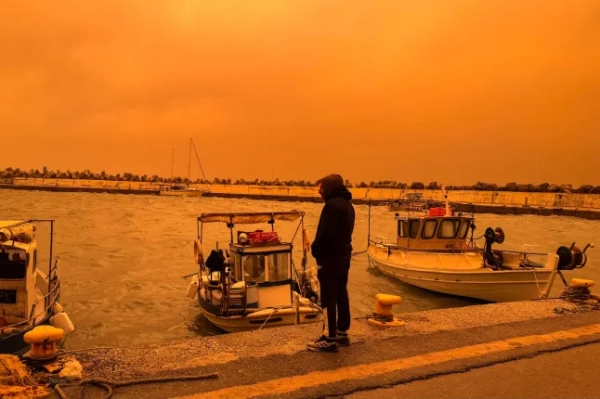 Місцевий мешканець гуляє портом Ієрапетра під час пилової бурі на грецькому острові Крит 1 квітня 2026 року. (Фото Елефтеріоса Еліса / AFP via Getty Images)