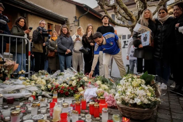 Батьки жертв несуть квіти, коли близько тисячі людей зібралися, щоб вшанувати пам'ять жертв трагедії в Кран-Монтані та закликати до справедливості та правди, Лютрі, Швейцарія, 31 січня 2026 року. (Зображення: EPA/VALENTIN FLAURAUD)