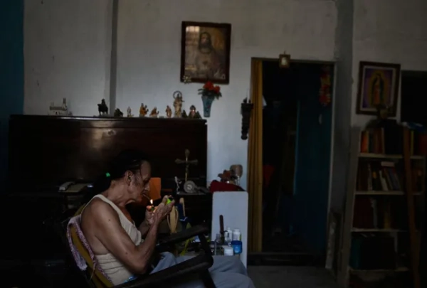 80-річний композитор Карлос Альварес курить, сидячи вдома під час відключення електроенергії, оскільки національна електромережа Куби обвалилася, повідомив оператор мережі країни, залишивши близько 10 мільйонів людей без електроенергії через нафтову блокаду, введену США, яка паралізувала і без того застарілу систему виробництва електроенергії острова, у Гавані, Куба, 16 березня 2026 року. REUTERS/Norlys Perez