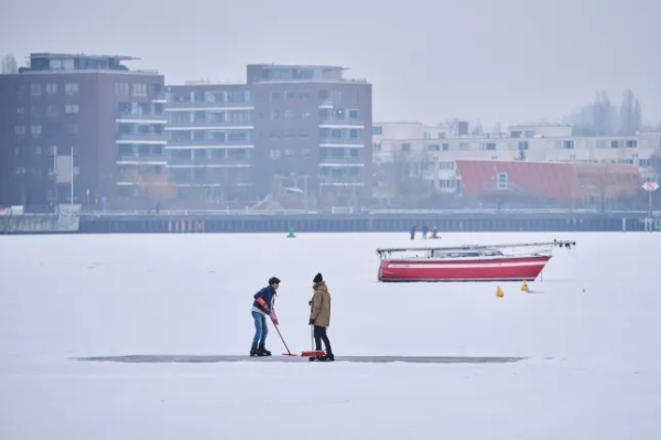 Люди проводять час на замерзлій воді на Руммельсбурзькому озері в Берліні, оскільки човни залишаються застряглими в льоду під час холодної зимової погоди, Німеччина, четвер, 5 лютого 2026 року.