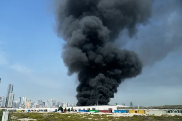 Чорний стовп диму піднімається зі складу в промисловій зоні міста Шарджа, Об'єднані Арабські Емірати, у неділю, 1 березня 2026 року, після повідомлень про іранські удари в Дубаї. (Фото AP/Altaf Qadri)