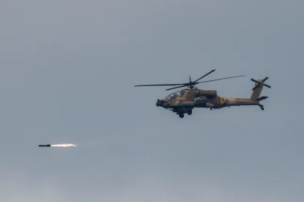 4 березня 2026 року ізраїльський ударний гелікоптер AH-64 Apache здійснює ракетний стрілянину під час польоту над позицією вздовж кордону між північним Ізраїлем та південним Ліваном. Ізраїльські військові 4 березня заявили, що розпочали удари по південному Лівану після заклику до евакуації всіх районів на південь від річки Літані. (Фото Джалаа МАРЕЯ / AFP via Getty Images)