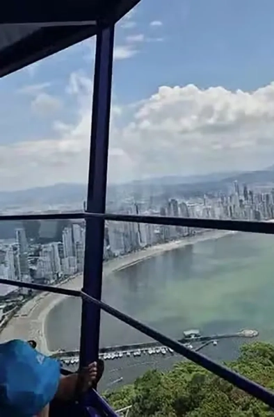 Це момент, коли наляканих туристів опускають на землю за допомогою мотузок після того, як атракціон зламався, в результаті чого вони застрягли майже на висоті 60 метрів над землею. Інцидент стався 30 січня в прибережному місті Балнеаріо-Камборіу, штат Санта-Катаріна, Бразилія. 59-метрова панорамна вежа, відома як Супергіроскопічна вежа, раптово перестала обертатися, перевозячи десятки туристів та персоналу. Адвокат Андре де Олівейра Коуту, який був на атракціоні зі своєю родиною, розповів, що потім атракціон почав повільно спускатися, перш ніж трястися, а потім завмер на місці. На відеозаписах видно пасажирів, які зависли високо над парком, поки рятувальні команди закріплювали мотузки та страхувальне спорядження, а потім спускали людей одного за одним вниз по стіні конструкції, використовуючи технічний доступ вежі. Відвідувачі розповіли, що ті, хто знаходився в кабіні, довго чекали, маючи обмежену інформацію, поки організовувалася евакуація. Пізніше співробітники парку повідомили пасажирів, що запобіжний замок атракціону автоматично спрацював після відключення електроенергії. Близько 40 людей, включаючи туристів та робітників, почали спускатися по мотузці, а пізніше прибула вантажівка з драбиною, щоб пришвидшити евакуацію тих, хто все ще застряг. Андре сказав: «Ми були там більше двох годин. Вони спускали людей по мотузці». Парк Уніпраяс повідомив, що всіх пасажирів евакуювали через аварійний вихід за підтримки навчених команд безпеки, і підтвердив, що атракціон проходитиме технічне обслуговування. Вежа Super Gyro, відкрита три місяці тому, може перевозити до 50 осіб на атракціон і виконує близько 300 поїздок на день, пропонуючи панорамні краєвиди з висоти майже 300 метрів (980 футів) над рівнем моря, обертаючись на вершині.