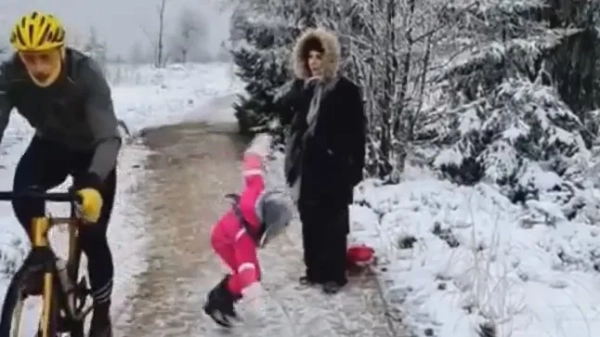 Молода дівчина летить на землю після того, як її збили коліном з дороги велосипедиста.