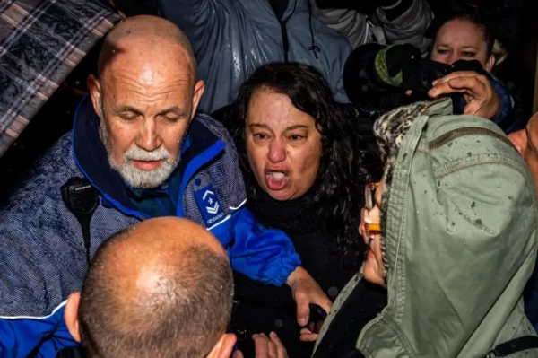 Гульсін Кая (в центрі), яка втратила сина Тайлана Каю у пожежі, стикається зі співвласником бару Le Constellation Жаком Моретті, коли той прибуває на слухання до прокуратури кантону Вале в Сьоні 12 лютого 2026 року. 41 людина, більшість з яких підлітки, загинула, а 115 отримали поранення внаслідок пожежі, яка охопила бар Le Constellation на гірськолижному курорті Кран-Монтана у новорічну ніч. (Фото Максима ШМІДА / AFP via Getty Images)