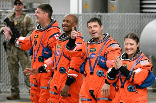 (Л/П) астронавт Канадського космічного агентства (CSA) Джеремі Хансен, спеціаліст місії Artemis II, астронавти NASA Віктор Гловер, пілот Artemis II, Рід Вайзман, командир Artemis II, та Крістіна Кох, спеціаліст місії Artemis II, виходять перед тим, як вирушити на стартовий майданчик для посадки на місячний корабель Artemis II у Космічному центрі Кеннеді на мисі Канаверал, Флорида, 1 квітня 2026 року. У середу троє чоловіків та одна жінка вирушать у першу з 1972 року пілотовану подорож на Місяць, знакову одіссею, метою якої є початок нової ери дослідження космосу для США. Місія NASA під назвою Artemis 2 готувалася роками після неодноразових невдач, але нарешті планується вилет з Флориди вже 1 квітня о 18:24 (22:24 за Гринвічем). (Фото Джима ВОТСОНА / AFP via Getty Images)