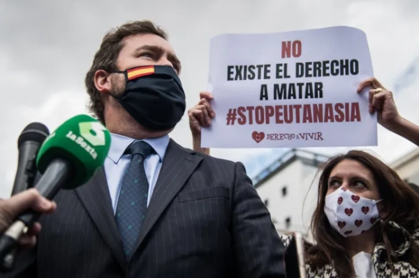 МАДРИД, ІСПАНІЯ – 18 БЕРЕЗНЯ: Депутат консервативної партії VOX Еспіноса де лос Монтерос висловлює свою підтримку демонстрації проти закону про евтаназію перед Конгресом депутатів 18 березня 2021 року в Мадриді, Іспанія. У 1989 році Марії Хосе Карраско було поставлено діагноз розсіяний склероз, хвороба, яка фізично погіршувала її до такої міри, що вона не могла себе утримувати. У 2019 році вона неодноразово просила дозволити їй покінчити життя самогубством, щоб зупинити свої страждання, але прохання не було успішним. За допомогою свого чоловіка, Анхеля Ернандеса, вона скоїла самогубство у квітні 2019 року. Ця справа викликала багато питань на національному рівні та сприяла просуванню чинного закону про евтаназію, який має бути схвалений сьогодні, 18 березня 2021 року, на Конгресі депутатів, попри численні суперечки, особливо з боку консервативних партій, що призвело до протесту біля воріт Конгресу під час голосування. (Фото Джоан Аменгуаль/VIEWpress)