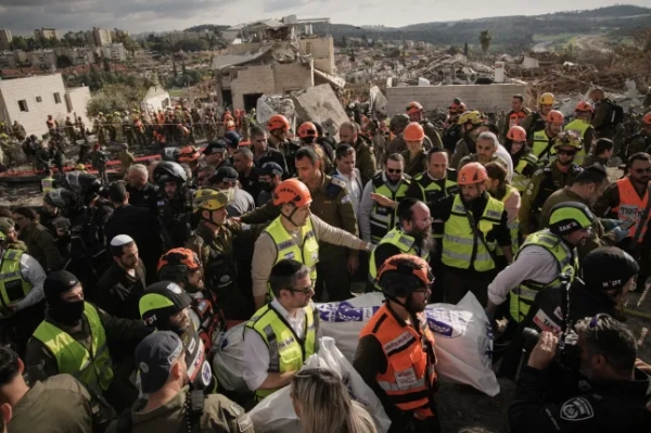 Рятувальники та військовослужбовці виносять тіло жертви з місця події, де кілька людей загинули внаслідок ракетного удару Ірану в Бейт-Шемеші, Ізраїль, у неділю, 1 березня 2026 року. (Фото AP/Лео Корреа)