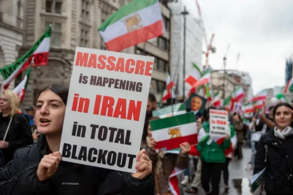 Люди у Великій Британії тримають плакати та іранські прапори на знак протесту проти розгону масових демонстрацій в Ірані.