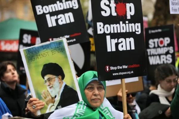 ЛОНДОН, АНГЛІЯ – 7 БЕРЕЗНЯ: Протестувальник тримає фотографію колишнього Верховного лідера Ірану аятоли Алі Хаменеї під час мітингу «Зупиніть війну» проти ударів по Ірану 7 березня 2026 року в Лондоні, Англія. Протестувальники зібралися в центрі Лондона, щоб виступити проти того, що вони вважають безрозсудною та незаконною війною Дональда Трампа проти Ірану, маршируючи від Вестмінстера до посольства США. (Фото Мартіна Поупа/Getty Images)