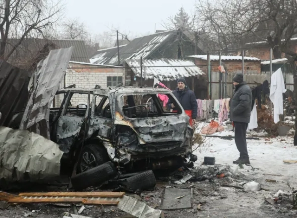 epa12777830 Місцеві жителі реагують на місце удару безпілотника по приватній будівлі в Харкові, північно-східна Україна, 26 лютого 2026 року, під час російського вторгнення. Щонайменше 10 людей отримали поранення внаслідок нічного обстрілу безпілотника та ракет, повідомила Національна поліція України. EPA/СЕРГІЙ КОЗЛОВ